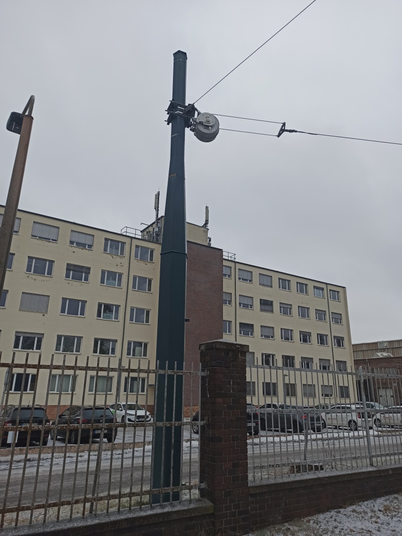 Крепление контактной сети к компенсатору с барабанами TENSOREX C+, на заднем плане — здание бывшего завода подъемно-транспортного оборудования («Кранбау») в Эберсвальде